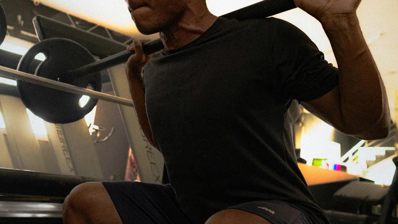 Athlete performing a barbell squat in a gym during strength training